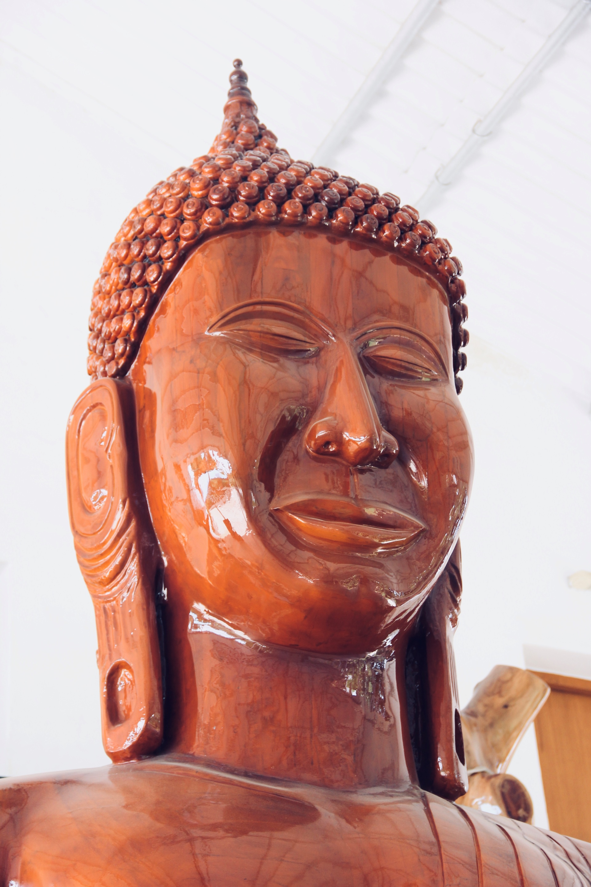 Close-up of a serene wooden Buddha head