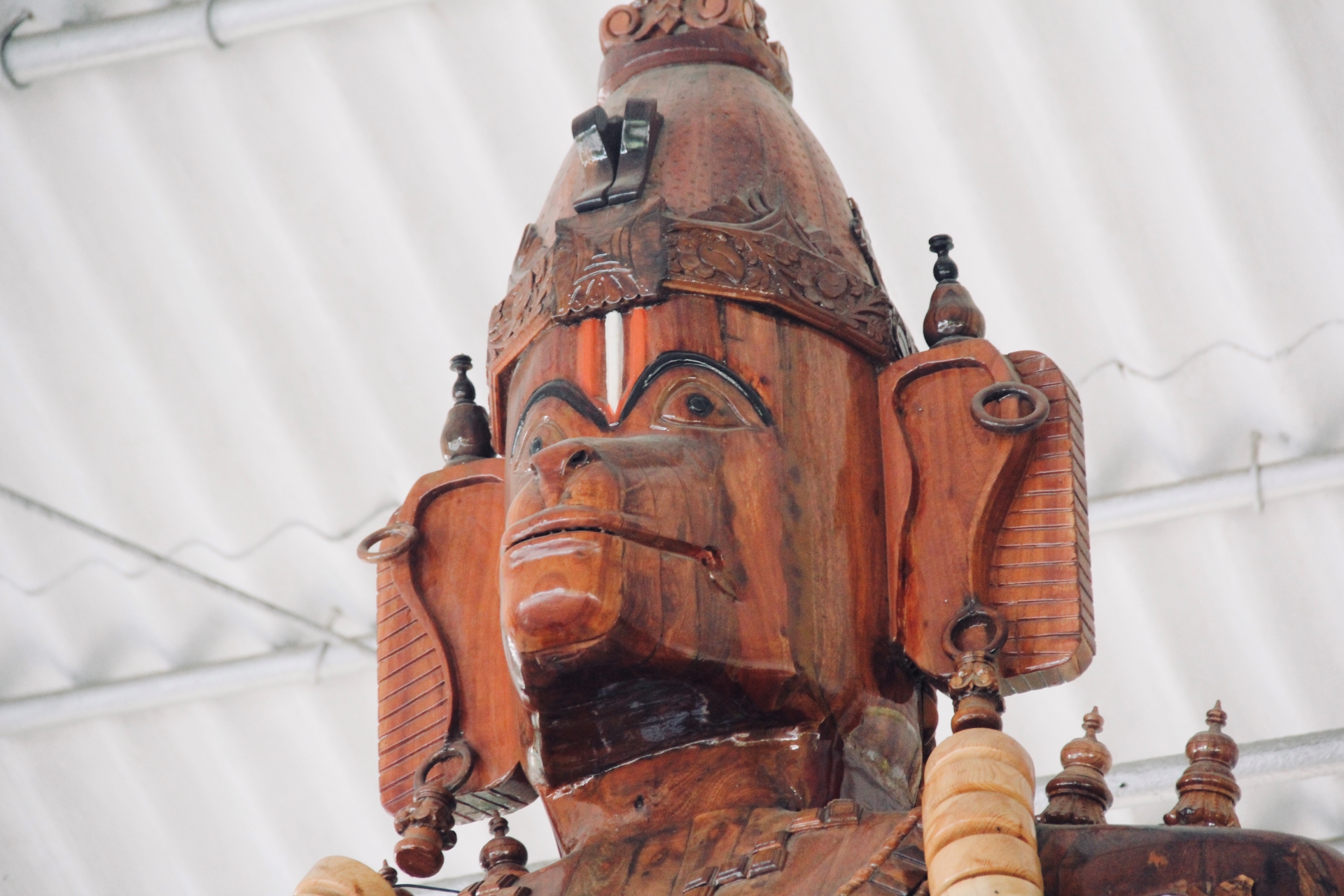 Close-up of a carved wooden deity's face and crown